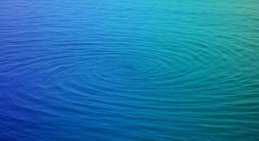 A blue and green water surface with a spiral pattern photo