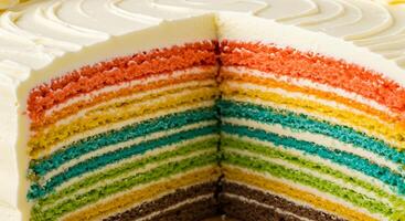 A close up of a rainbow cake with a slice missing photo
