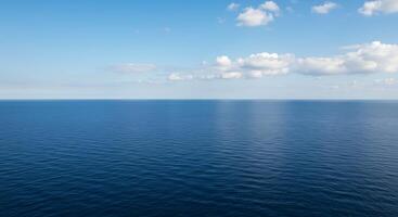 A large body of water with a few clouds photo