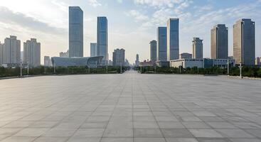 A large empty paved area with tall buildings in the background photo
