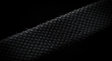A close up of a black fabric with a small hole photo