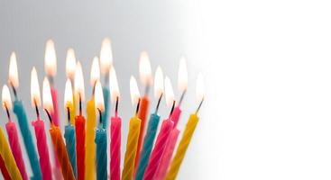 Many colorful candles are lit in a row photo