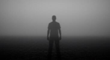 A man standing in the fog with his shadow photo