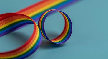 A rainbow colored ribbon on a blue surface photo
