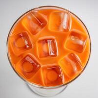 An orange drink with ice cubes in it photo
