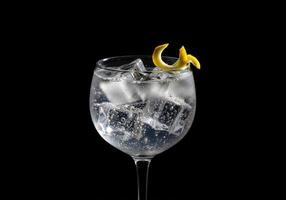 A gin and tonic with ice and a lemon wedge photo