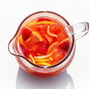 A pitcher of strawberry lemonade with orange slices photo