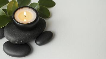 A candle and stones with leaves on a white background photo