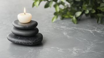 A candle is sitting on top of a stack of stones photo