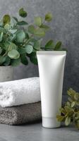 This blank cosmetic tube sits elegantly next to neatly folded towel, creating sense of calm and serenity photo