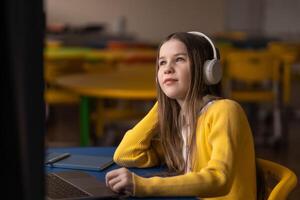 Girl in headphones explores future skills through calm audio learning in stress-free classroom photo