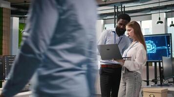 júnior dev y colega en oficina revisando ai sistema métrica, supervisión actuación tableros de instrumentos. tecnología empresa programador y joven hembra ingeniero Afinación neural redes, cámara un video