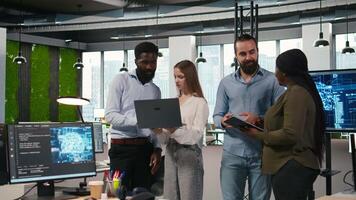 Portrait of teamworking programmers in office developing apps using AI automation. Team of smiling IT experts working on devices, debugging applications with artificial intelligence, camera A video