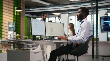 Admin in tech startup office using PC, compiling software patches to fix bugs, troubleshooting backend operations. IT expert running diagnostics, resolving system crashes via terminal, camera A video
