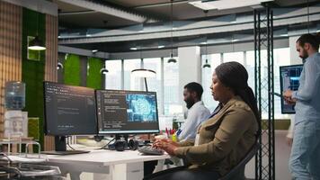 Female software developer using artificial intelligence to optimize performance and forecast issues. Woman in office training machine learning models using computer, camera A video