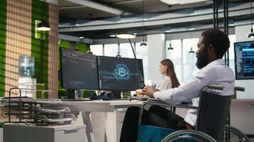 computer scienziato con paraplegia nel ufficio automatizzare ripetitivo compiti con ai script. esso professionale nel sedia a rotelle utilizzando artificiale intelligenza per velocità su caratteristica implementazione, telecamera un' video