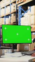 Vertical Black female worker manages orders next to green screen display, showcasing warehouse automation tools and inventory control dashboards. E-commerce order processing with storage racks. Camera A. video