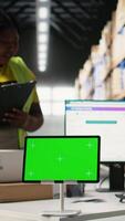 Vertical African American employee uses a isolated mockup screen on computer, business software used for supply chain system and package tracking service. Real-time order fulfillment displays. Camera A. video