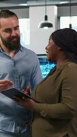 Vertical Team of programmers in office automating repetitive tasks using AI scripts on devices. Teamworking IT experts brainstorming, using artificial intelligence to speed up feature implementation, camera A video