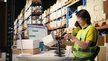 Tired overworked person in hi vis vest scanning shipping labels, being sleepy and bored with his tasks in the warehouse. Managing order fulfillment with a scanner and tracking software. Camera A. video