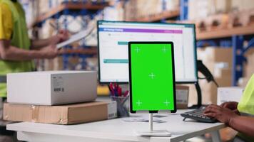 Warehouse employee in hi vis vest uses copy space display with technology of shipping software, packaging systems and inventory management tools. E-commerce logistics. Camera B. video