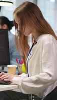 Vertical Young programmer in office requests help from IT experts detecting and blocking hacker intrusion. Intern assisted by staff members coordinating incident response for network attack, camera A video