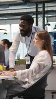 Vertical Cheerful startup manager satisfied with progress oj junior dev learning how to use machine learning tech. Team leader doing fist bump with intern in office, satisfied with work done, camera A video