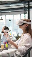 Vertical Junior dev using virtual reality at work, testing machine learning algorithms. Young woman wearing VR goggles equipment scaling productivity with AI large language model code, camera A video