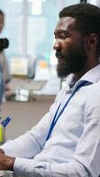 Vertical Software developer testing machine learning algorithms and listening music at work. African american man wearing headphones scaling productivity with AI large language model, camera A video