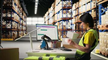 Male worker managing package labeling using shipment details adhesive tags, handling order processing and preparing the packages for distribution. Online shopping fulfillment center. Camera A. video