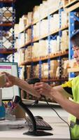 Vertical Asian male staff uses handheld scanner to register airway bill information, updating the package tracking software in real time with barcode reader and shipment details. Stock room. Camera A. video