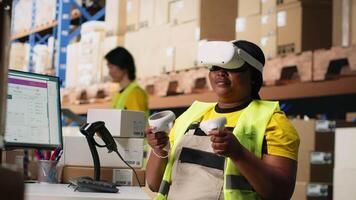 Black female employee with virtual reality glasses handling orders fulfillment via 3D simulation, parcel status on package tracking software. Artificial intelligence inventory control. Camera B. video