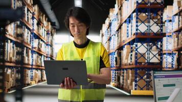 Asian male employee oversees product handling and order fulfillment, ensures inventory control using technology and packages coordination for efficient local delivery service. Camera B. video