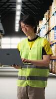 Vertical Warehouse employee in hi vis vest preparing packages for local delivery, processing custom orders and handling merchandise within large business operation focused on e-commerce. Camera A. video
