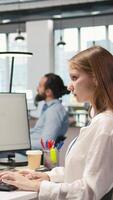 Vertical Junior dev testing machine learning algorithms and listening music at work. Young woman wearing headphones scaling productivity with AI large language model written code, camera A video
