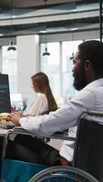 Vertical IT professional in wheelchair in inclusive office developing software applications using AI automation. Computer scientist with paraplegia debugging applications with artificial intelligence, camera A video
