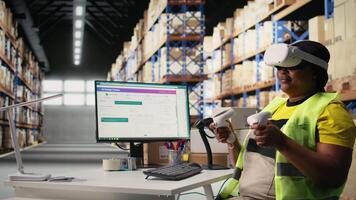 Black female employee with virtual reality glasses handling orders fulfillment via 3D simulation, parcel status on package tracking software. Artificial intelligence inventory control. Camera A. video