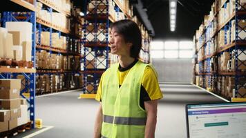Asian male employee oversees product handling and order fulfillment, ensures inventory control using technology and packages coordination for efficient local delivery service. Camera A. video