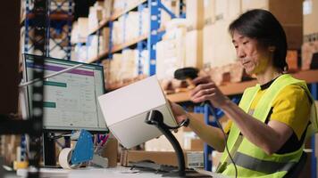 Industrial staff member in big fulfillment center scanning tags on boxes, registering shipping labels for express delivery logistics with a barcode scanner. Order tracking for e-commerce. Camera B. video