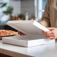 A woman is opening a pizza box photo