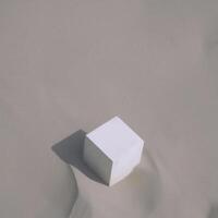 A white cube sitting on top of a sand dune photo