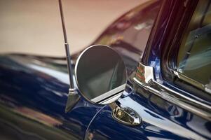 Close-Up of a Vintage Car's Side Mirror with Shiny Blue Paint photo