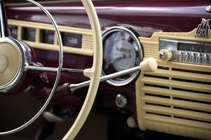 Vintage Car Dashboard Featuring Steering Wheel and Retro Radio Dials photo