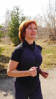 Woman doing running in place as part of her outdoor workout. Cardio warm-up, body activation, and fitness routine without equipment. High quality 4k footage video