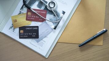 Multiple credit cards on medical documents with stethoscope, representing various payment options. photo