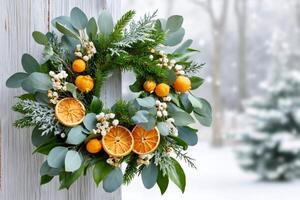 Christmas wreath hanging on a white wooden door with snowy winter forest in background photo