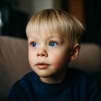 Portrait of a Young Boy with Striking Blue Eyes. A close up image of a toddler's pensive expression. photo