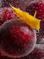 Close up of Red Plums Submerged in Sparkling Water with a Lemon Slice. photo