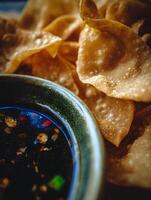 Close Up of Crispy Fried Wonton Chips with Spicy Dipping Sauce. photo