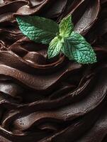 Close up of rich dark chocolate with fresh mint leaves. A delectable image perfect for food blogs, chocolate packaging, or dessert menus. photo